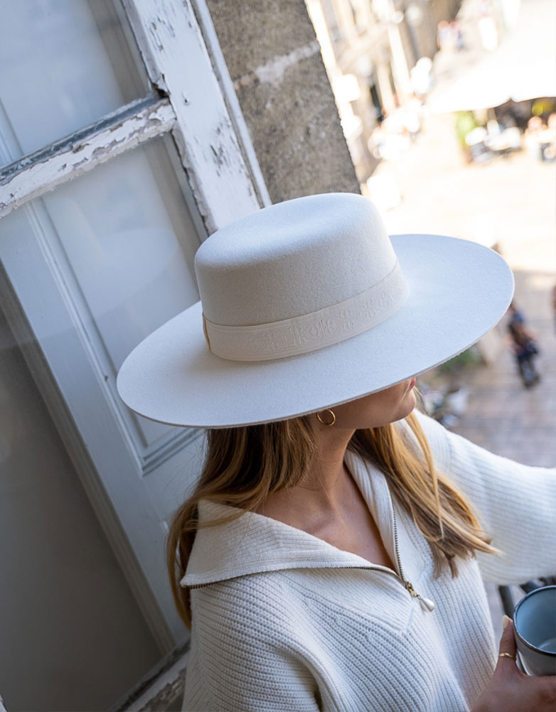femme assise avec un chapeau en feutre de laine blanc 